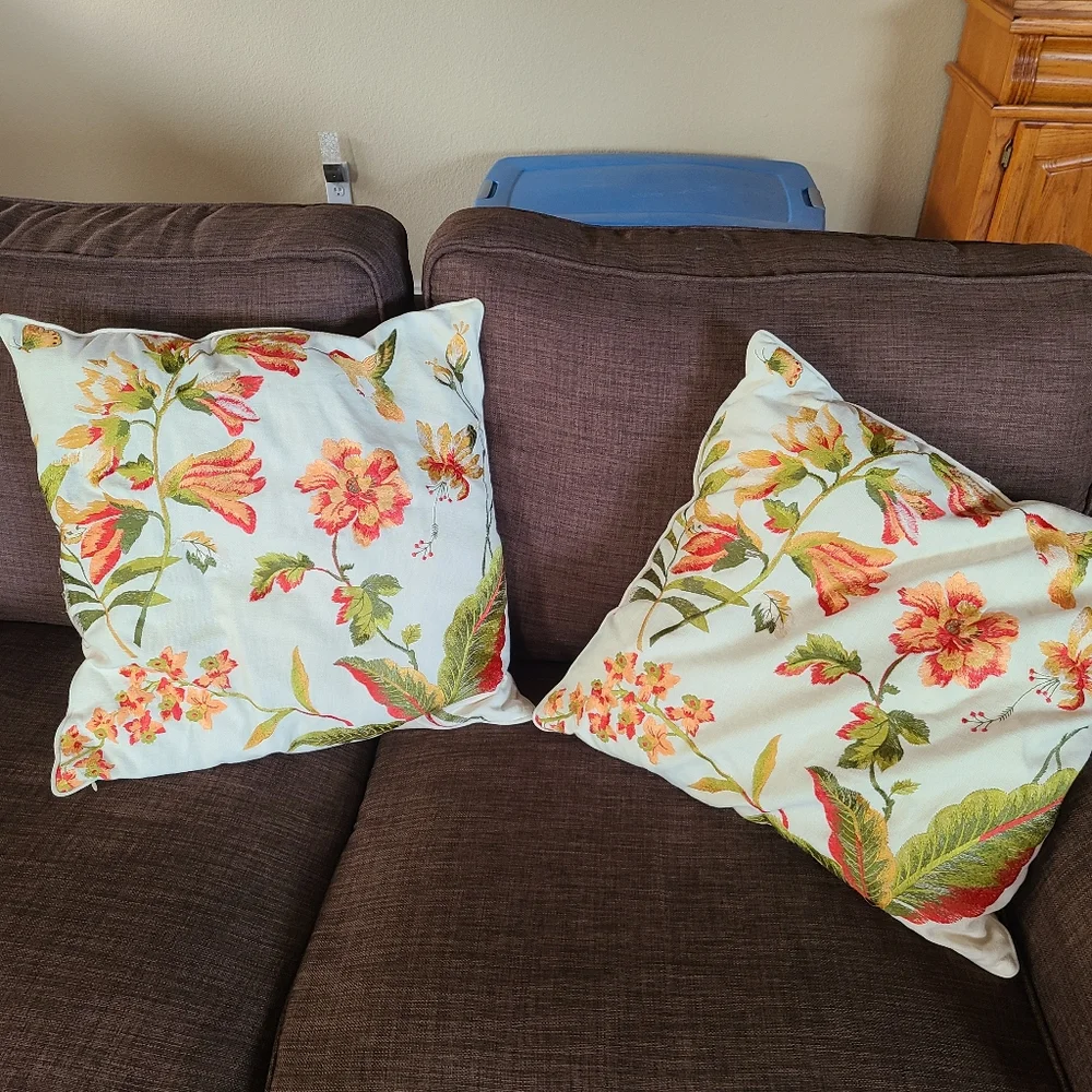 2 pillows with embroidered flowers and hummingbirds